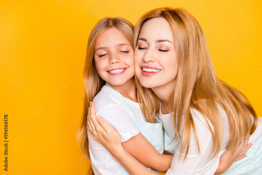 Close up portrait of two people lovely mommy mom mum and cute adorable sweet lovely small daughter wearing white tshirts aprons hugging each other with toothy smile isolated on background copy-space Close up portrait of two people lovely mommy mom mum and cute adorable sweet lovely small daughter wearing white tshirts aprons hugging each other with toothy smile isolated on background copy-space