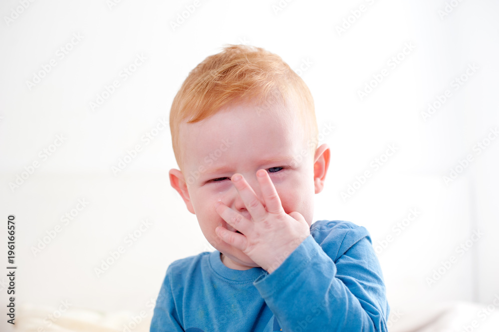 Crying redhead baby on the white background Crying redhead baby on the white background