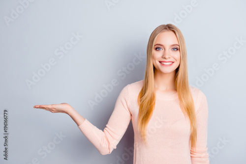 People person edvice pointer pointing demonstrate balance option service tips recommend concept. Portrait of lovely pretty lady holding invisible product on hand isolated on gray background copyspace