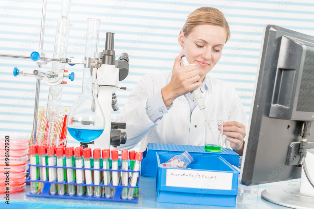 Experiments in the chemical laboratory, Female researcher using her test tube in a laboratory