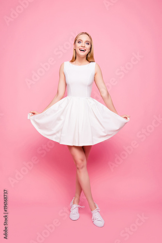 Trendy emotion feeling rest relax weekend summer spring holiday party celebrate girlfriend concept.  Vertical full-length full-size portrait of cute girl touching bottom of dress isolated background