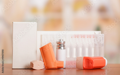 Two portable inhaler with dispenser and a box of ampoules on table