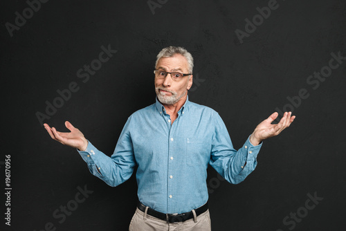 Fotografie Image of intelligent gentleman 50s wearing businesslike outfit throwing up hands