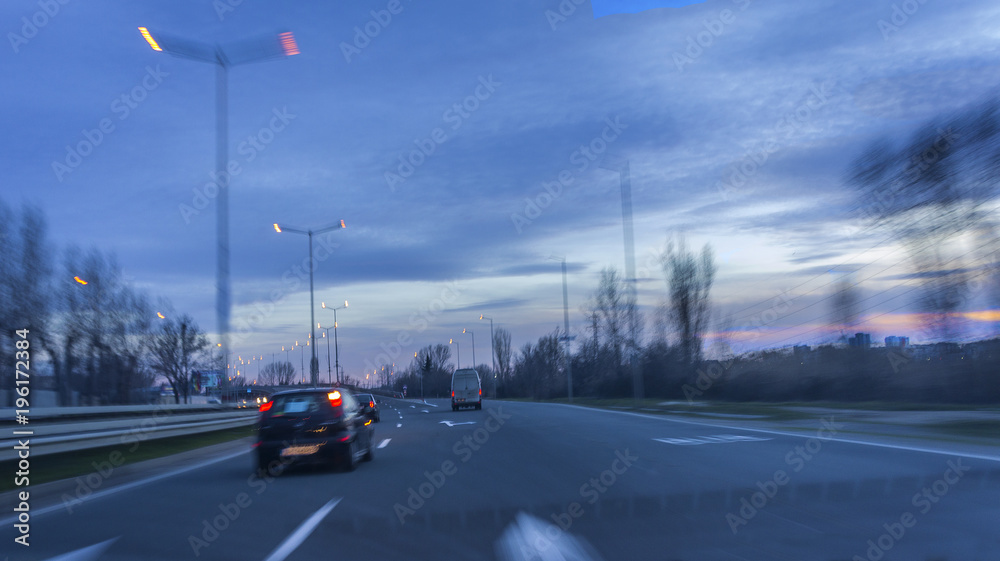 urban night landscape on a road with smashed high-speed cars. blurry effect of vehicle speed.