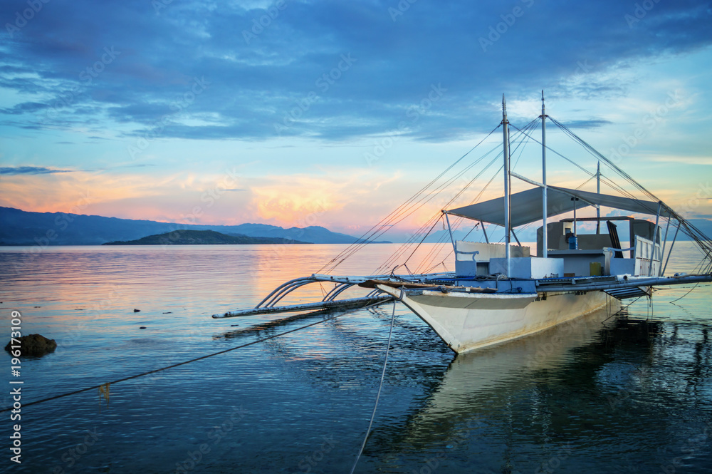 Banka, traditional filipino fishing boat at sunset, Cebu island, The  Philippines Stock Photo