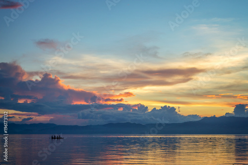 Silhouette of a small boat on the ocean at sunset, Cebu island, the Philippines