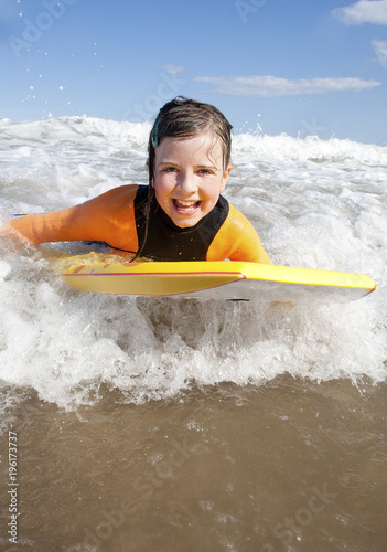 Little girl Bodyboarding in the Sea © dglimages