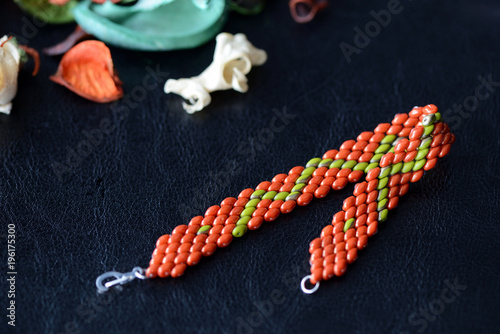 Beaded bracelet made of superduo beads on a dark background close up photo