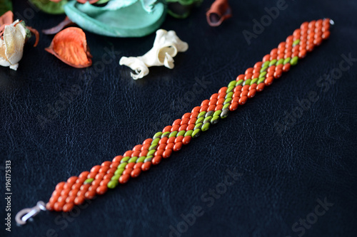 Beaded bracelet made of superduo beads on a dark background close up photo