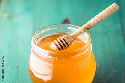 Honey in a glass bottle On blue wood in low light 