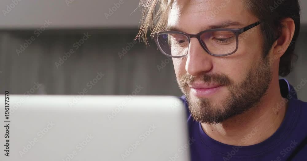 A man at home uses her laptop to: send work mails, shop online, surf on social networks. Concept of: shopping, work, relaxation and technology. A man at home uses her laptop to: send work mails, shop online, surf on social networks. Concept of: shopping, work, relaxation and technology.