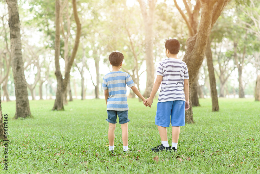 Two boy hold their hand and walk