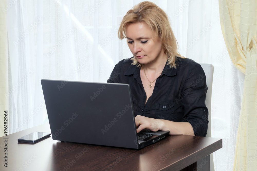 Middle aged woman is working in the office at home. Middle aged woman is working in the office at home.