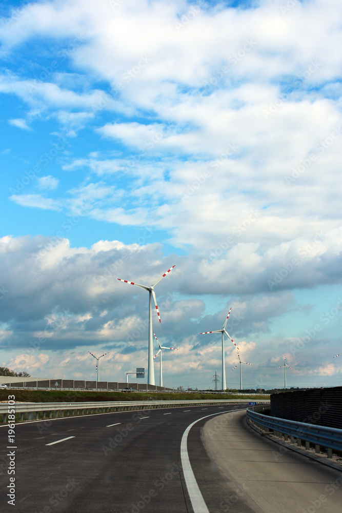 windmill near the road and beautiful sky