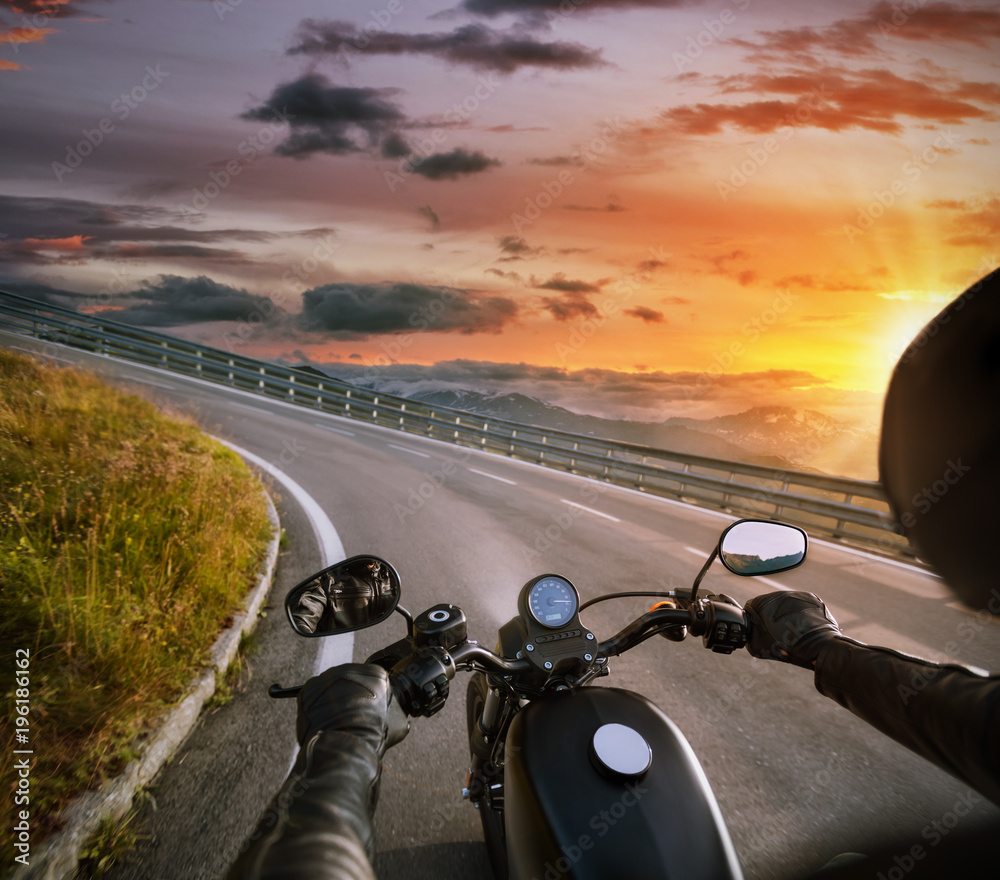 Naklejka premium POV motocyklisty trzymającego kierownicę podczas jazdy w Alpach