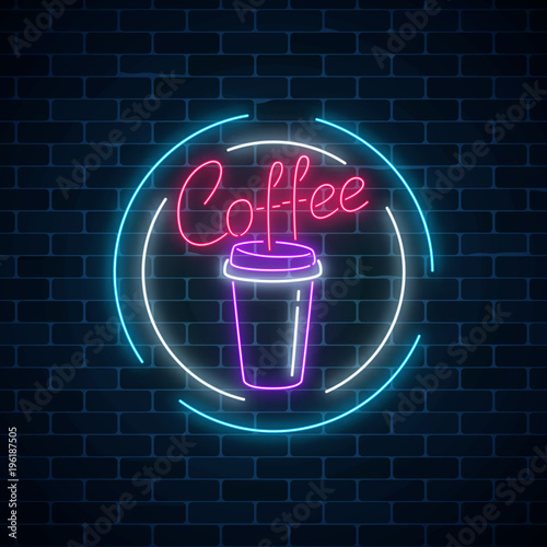Glowing neon coffee cup sign on a dark brick wall background. Night advertisement symbol of coffee.