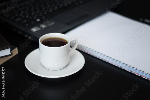 working place with a cup of coffee for business people on black table