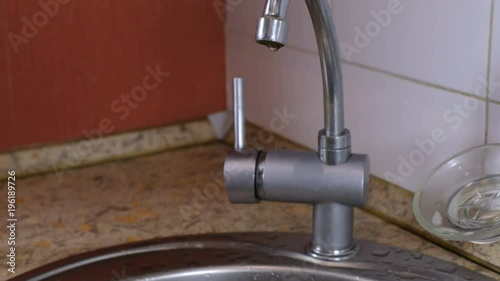 Water slowly drips from the tap. photo