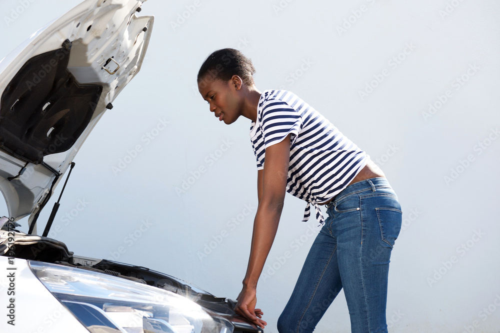 young woman looking under the hood of broken down car on road Stock Photo |  Adobe Stock