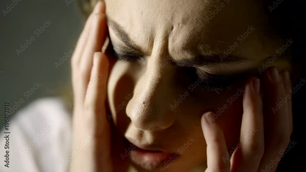 close-up of face of young pretty woman with strong migraine, she is suffering and touching her face close-up of face of young pretty woman with strong migraine, she is suffering and touching her face