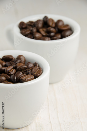 Coffee. Coffee cups and coffee beans on red wooden background.