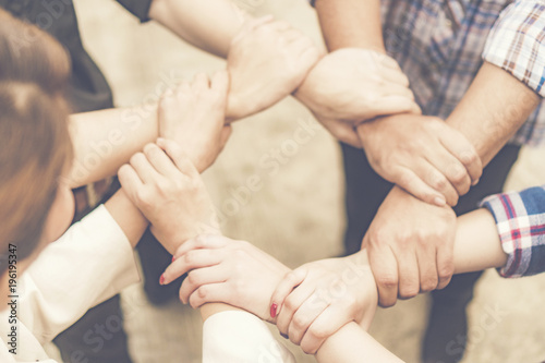 Group of business people crossed arms in pile for win. Stack of hands. Cooperation concept