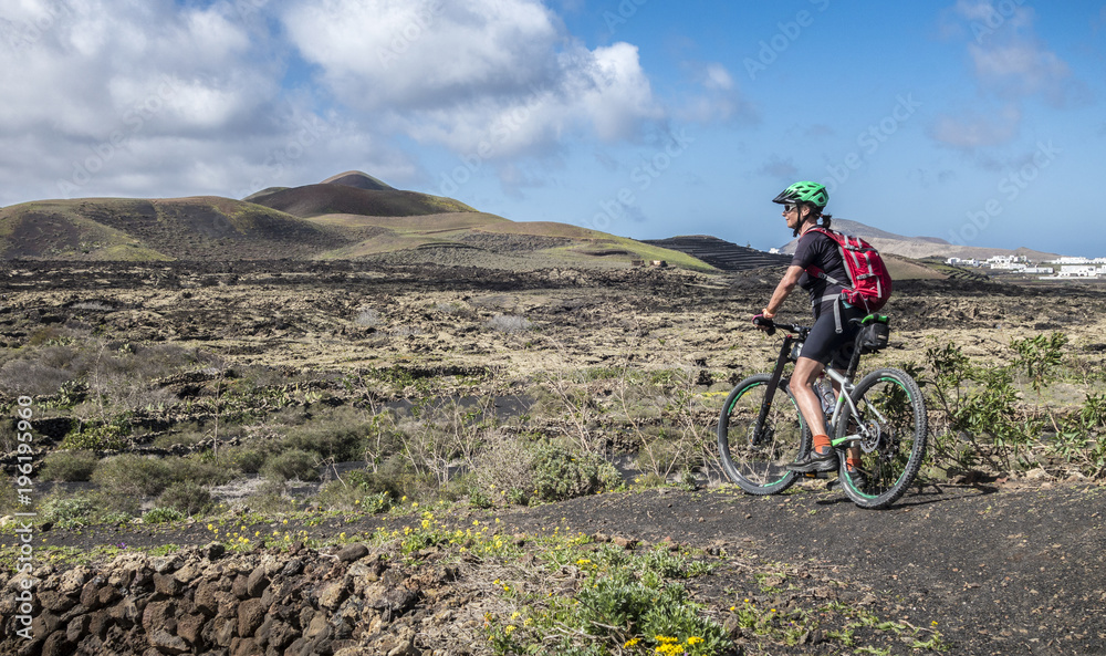Seniorin unterwegs mit dem Mountainbike auf der Insel Lanzarote, Kanarische Inseln