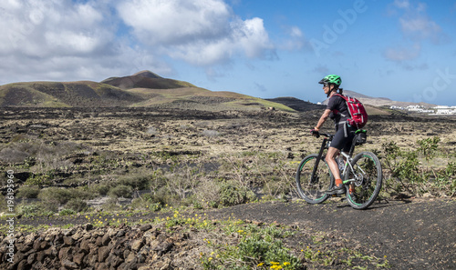 Seniorin unterwegs mit dem Mountainbike auf der Insel Lanzarote, Kanarische Inseln