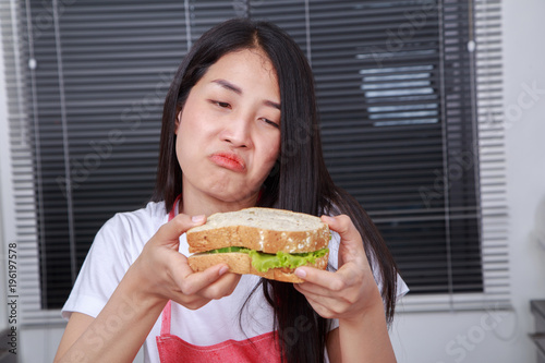 woman with a sandwich in kitchen room