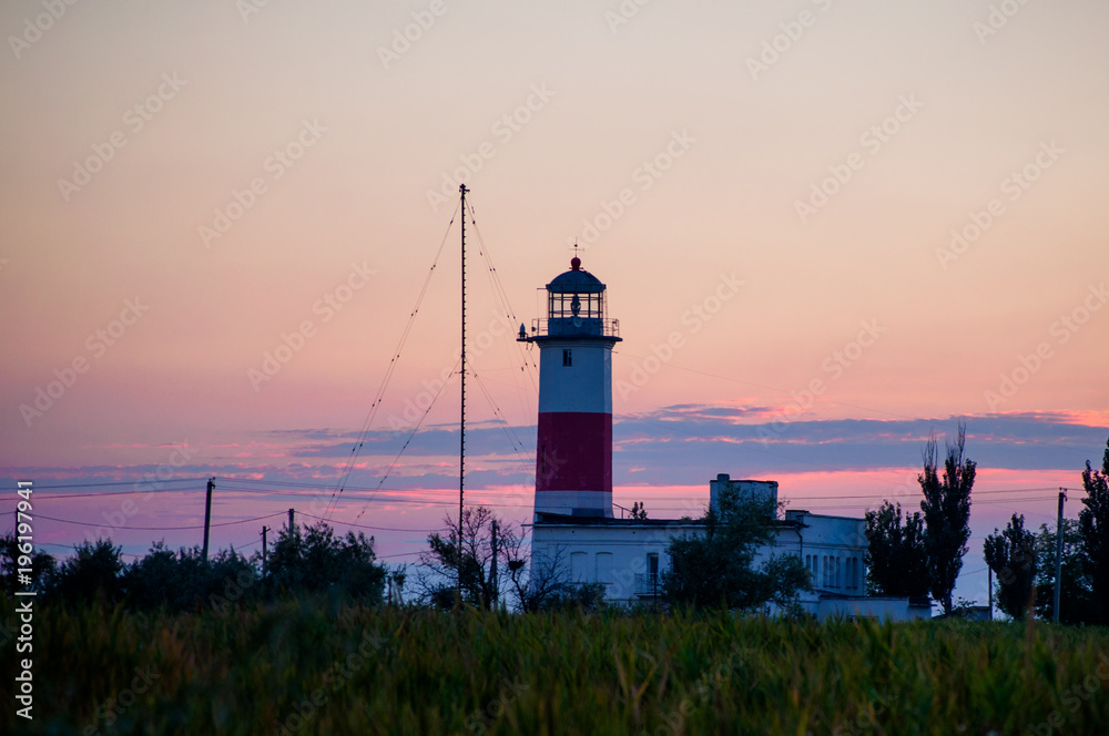 Silhouette of a lighthouse against the background of the evening sky.