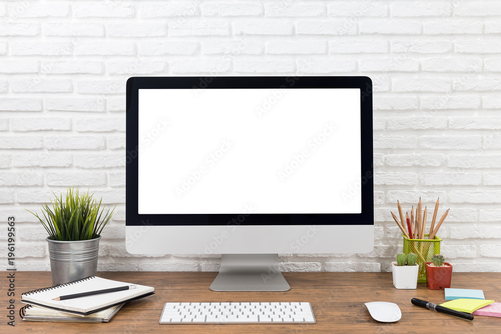 workspace with computer with blank white screen, and office supplies on a wooden desk workspace with computer with blank white screen, and office supplies on a wooden desk