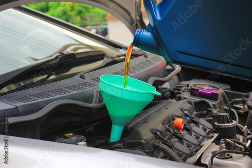 Close up of Pouring fresh oil to car engine