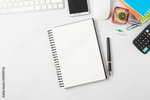 Top view, empty notebook and office supplies on the desk.