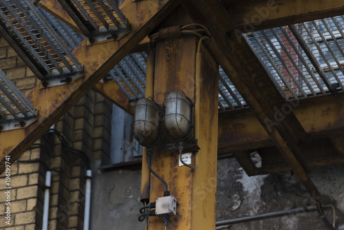 Alte Lampe an einer rostigen Stahltreppe, Gelbe rostige Stahltreppe mit Außenbeleuchtung