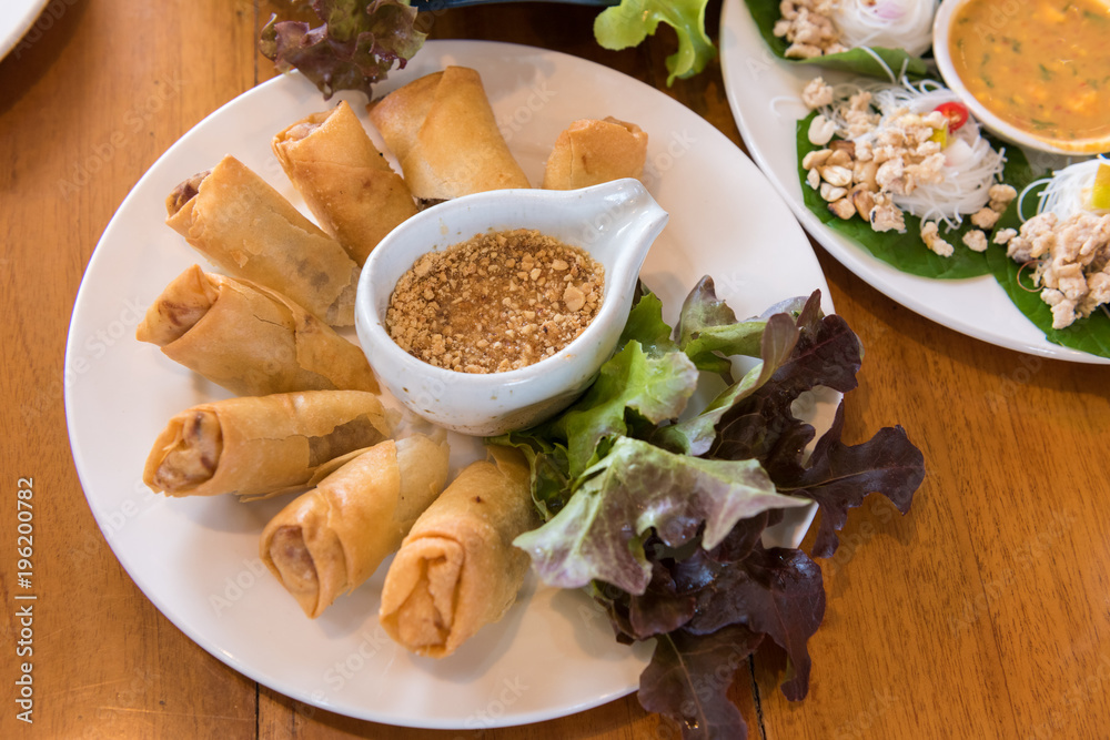 Deep fried spring rolls with vegetable in white dish on table Deep fried spring rolls with vegetable in white dish on table