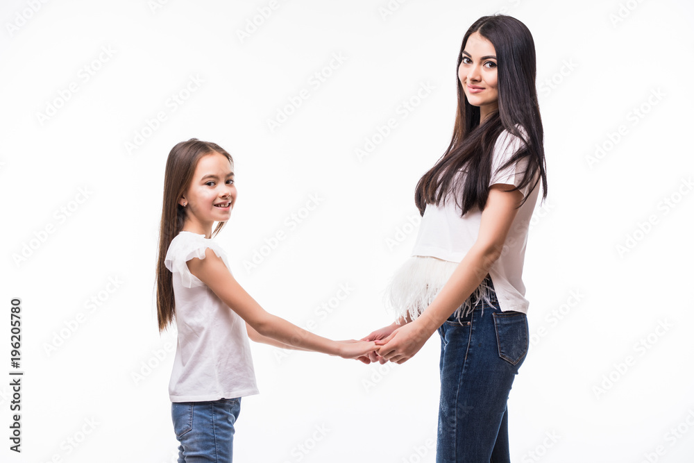 mother and daughter holding for hands looking to each other and smiling isolated on white background mother and daughter holding for hands looking to each other and smiling isolated on white background