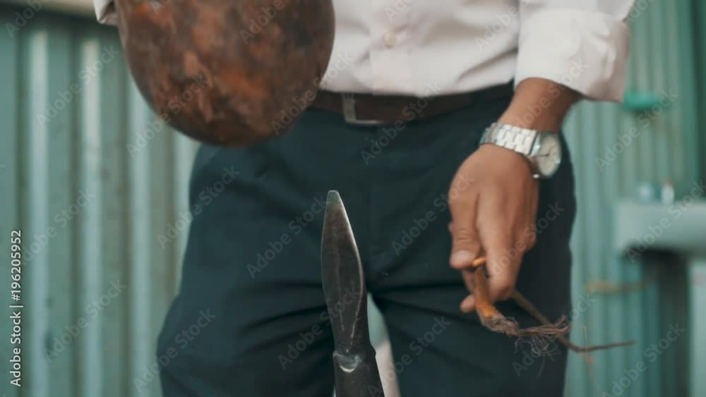 Vietnamese man pulls open the shell of a coconut after having using a spear to split open the shell Vietnamese man pulls open the shell of a coconut after having using a spear to split open the shell