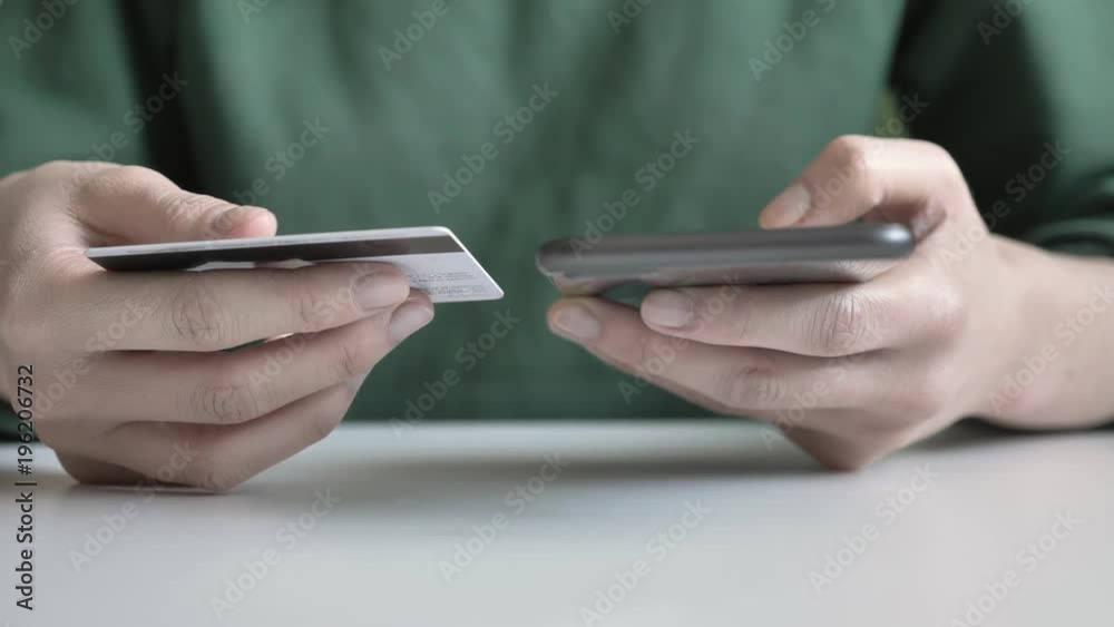 Female hands hold a large black smartphone and credit card, online banking, shopping 60 fps Female hands hold a large black smartphone and credit card, online banking, shopping 60 fps
