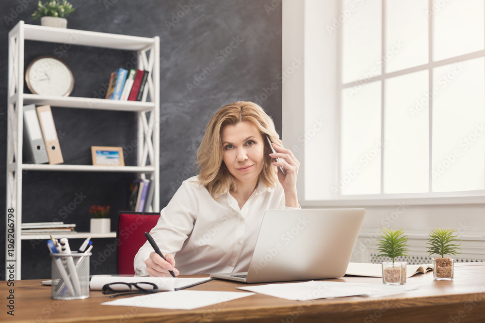 Successful business woman at work talking on phone Successful business woman at work talking on phone