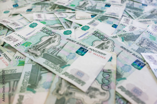 Obraz na plátně A lot of banknotes in nominal value of one thousand Russian rubles lie in a disorderly heap on the table