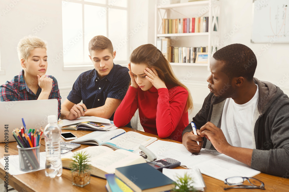 Multiethnic classmates preparing for exams together Multiethnic classmates preparing for exams together