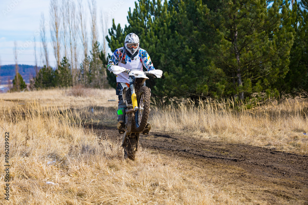 Motocross rider in action on the off-road in nature next to small czech town Pribram, Czech republic Motocross rider in action on the off-road in nature next to small czech town Pribram, Czech republic