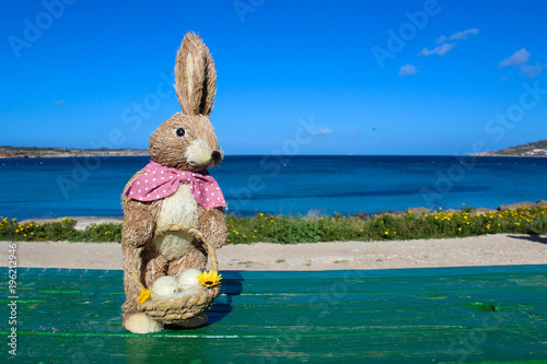 female easter bunny holding basket with eggs photo