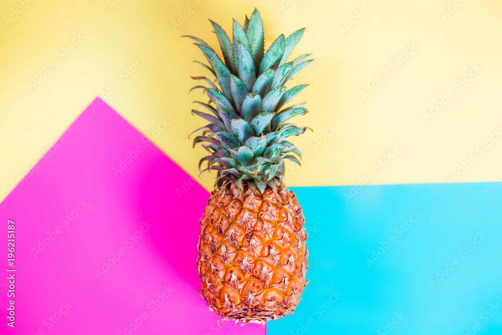 pineapple fruit on blue yellow and pink background