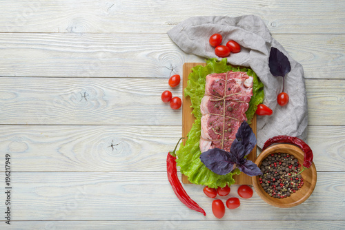 raw meat with ingredients on a wooden background
