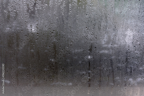 Moisture on the glass  formed in raindrops.