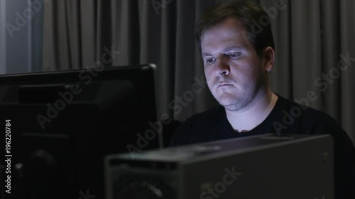 Man in dark office or lab using computer.
 photo