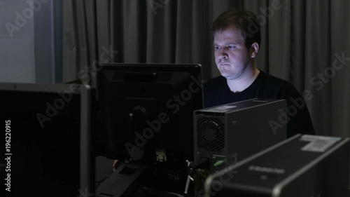Man in dark office or lab using computer.
 photo