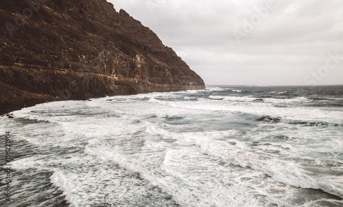 Coastal hill and wavy ocean