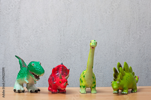 Fototapeta Naklejka Na Ścianę i Meble -  Four dinosaurs toys standing on a wooden floor.